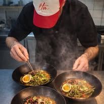 Cuisiner dans une assiette à chapeau rouge, en servant des bols de nouilles fumantes dans une cuisine