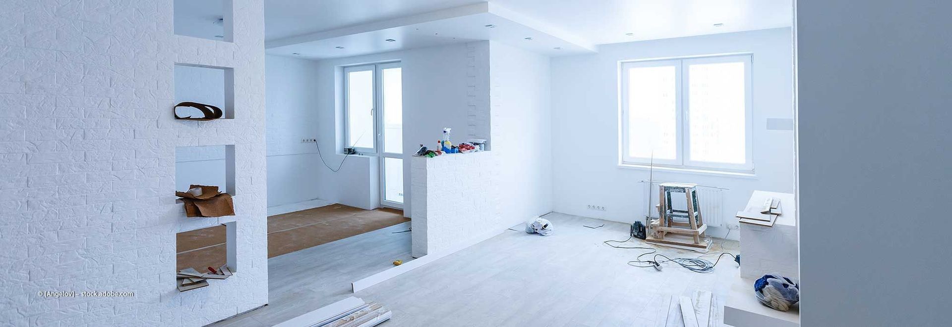 Weißes Interieur, das gerade renoviert wird, mit Licht aus den Fenstern.