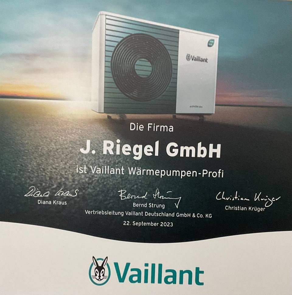 Mann mit Mütze und Schürze inspiziert orangefarbenen Warmwasserbereiter im Hauswirtschaftsraum.