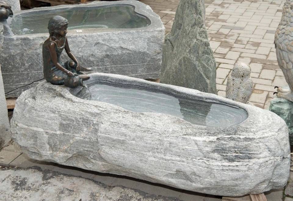 Steinbrunnen mit Kinderstatue; mit Wasser gefülltes Becken; Aussenanlage mit weiteren Steinskulpturen.