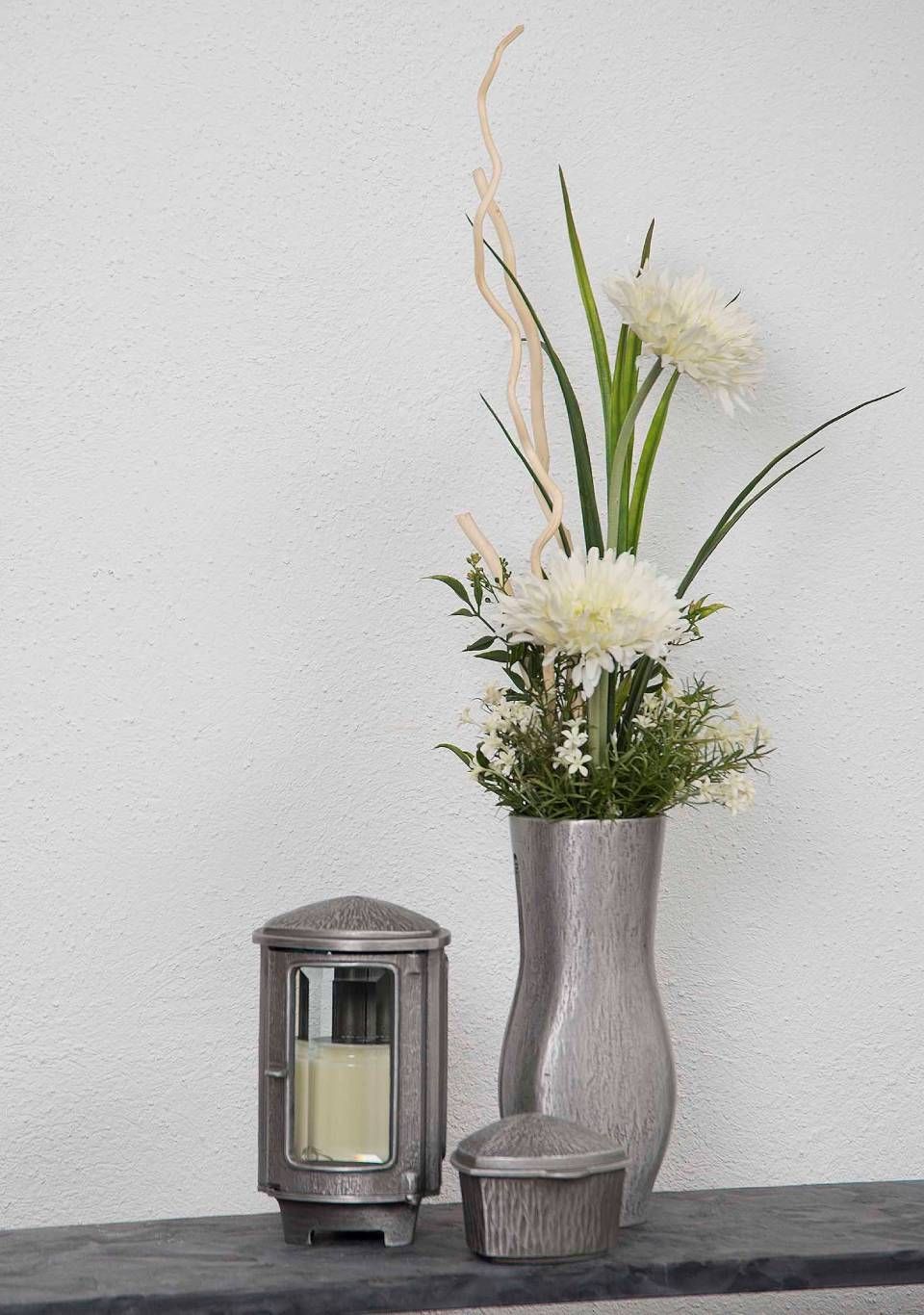 Silberne Vase mit weissen Blumen, einer Laterne und einer kleinen Schachtel.
