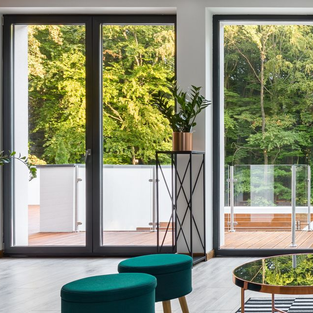 Un salon équipé d'une porte-fenêtre en aluminium de couleur noir