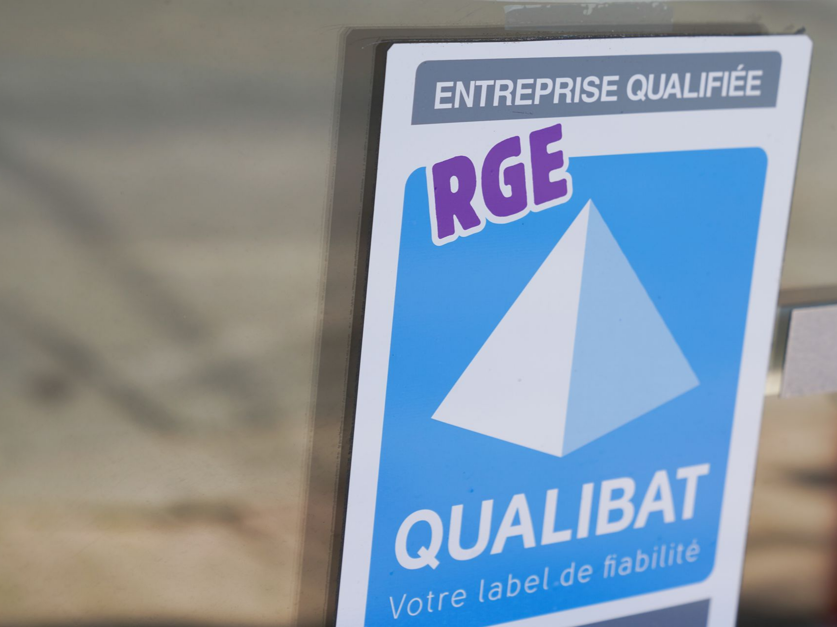 Logo RGE Qualibat affiché sur la fenêtre d'un bâtiment