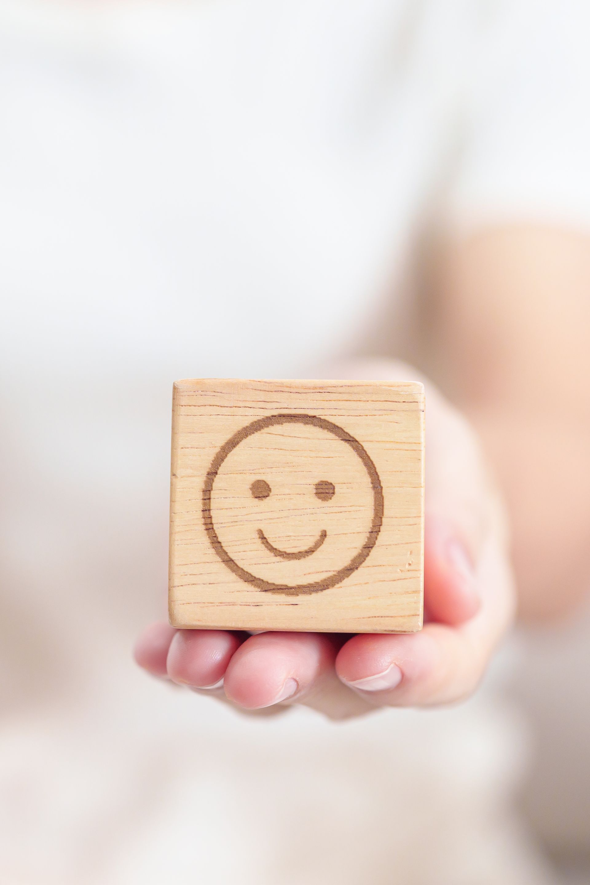 Cube en bois arborant un visage souriant