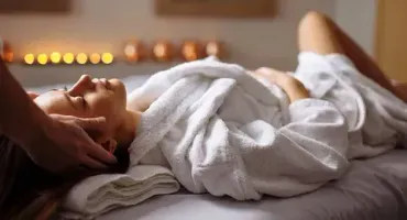 Una mujer está acostada en una cama recibiendo un masaje.