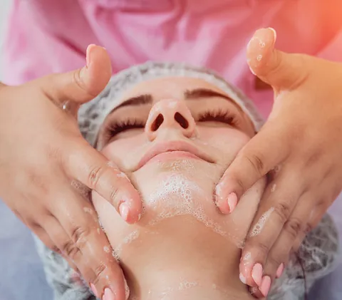 Una mujer está recibiendo un tratamiento facial en un salón de belleza.