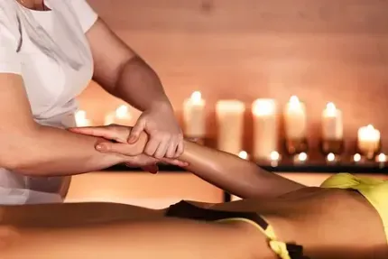 Una mujer está recibiendo un masaje en un spa con velas de fondo.