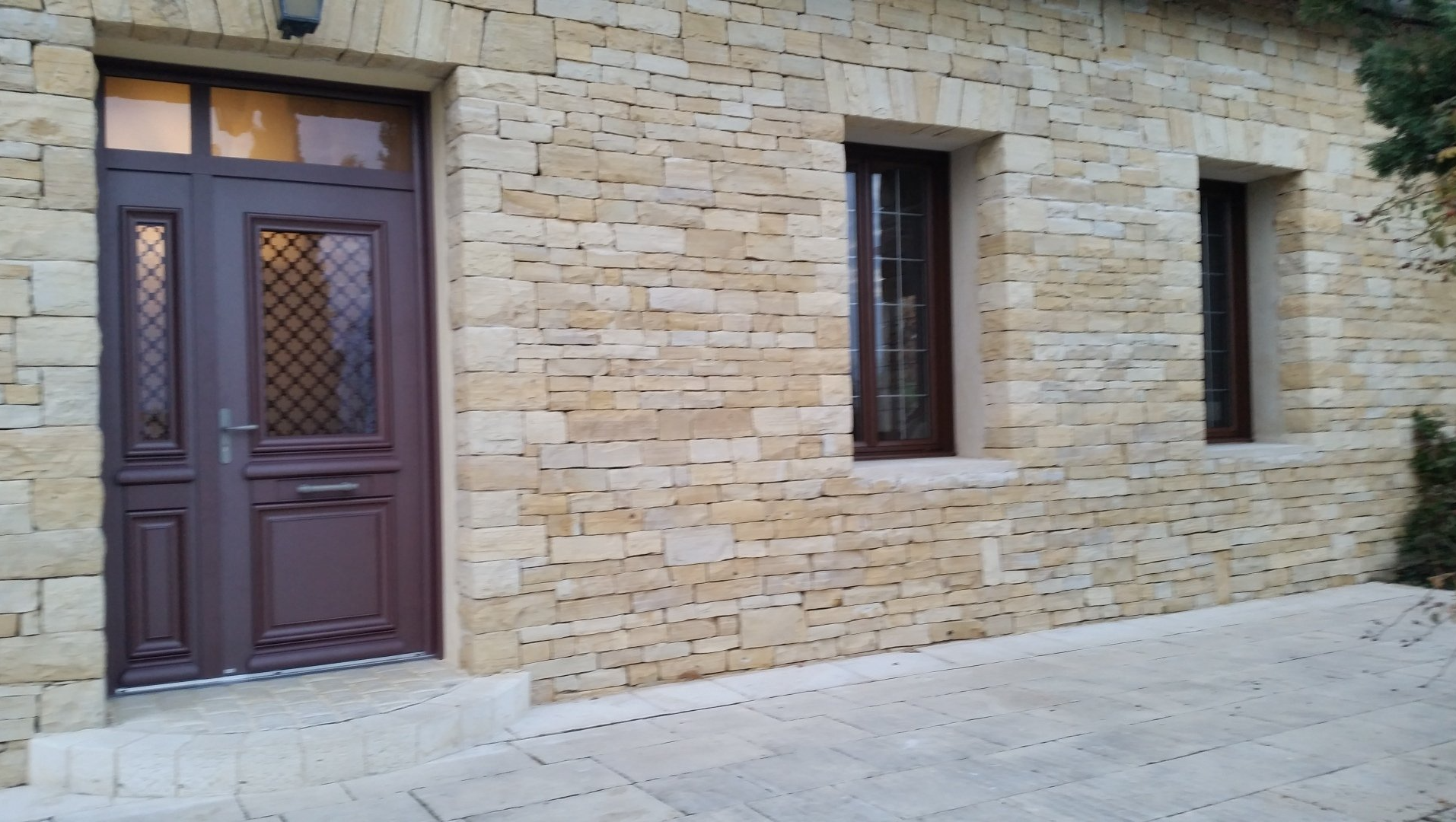Porte d'entrée marron rouge maison mur en pierre