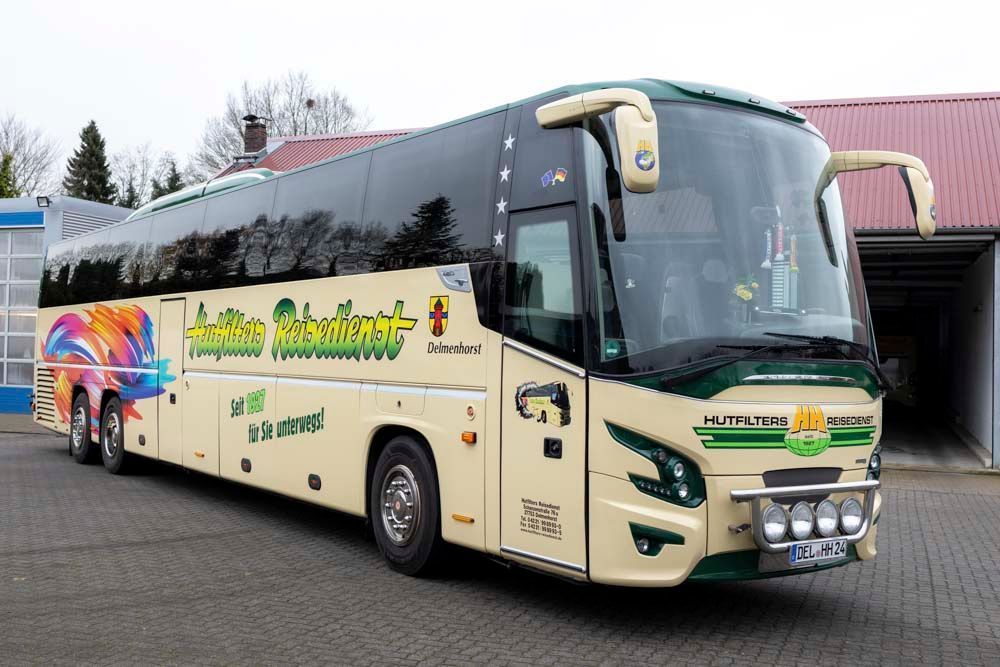 Ein großer Bus parkt vor einem Gebäude.