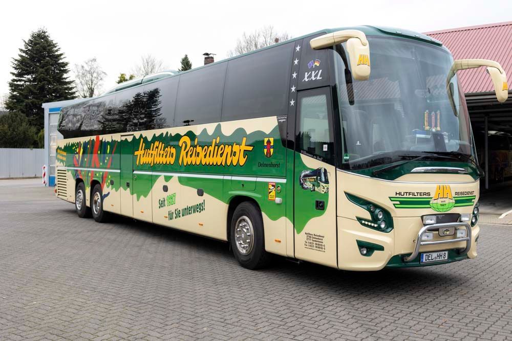 Ein großer grün-weißer Bus steht auf einem Parkplatz.