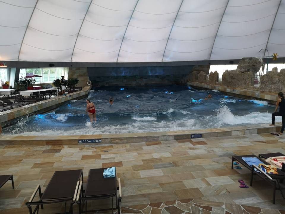 Una grande piscina coperta con persone che nuotano al suo interno