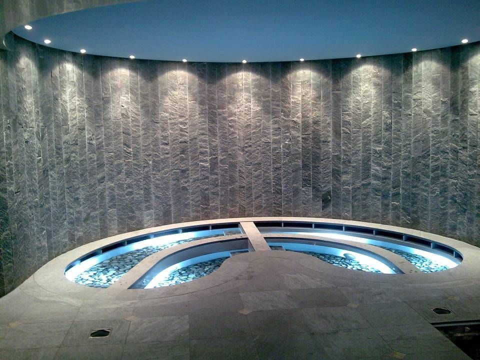 Ein grosser runder Pool mit einem Wasserfall im Hintergrund