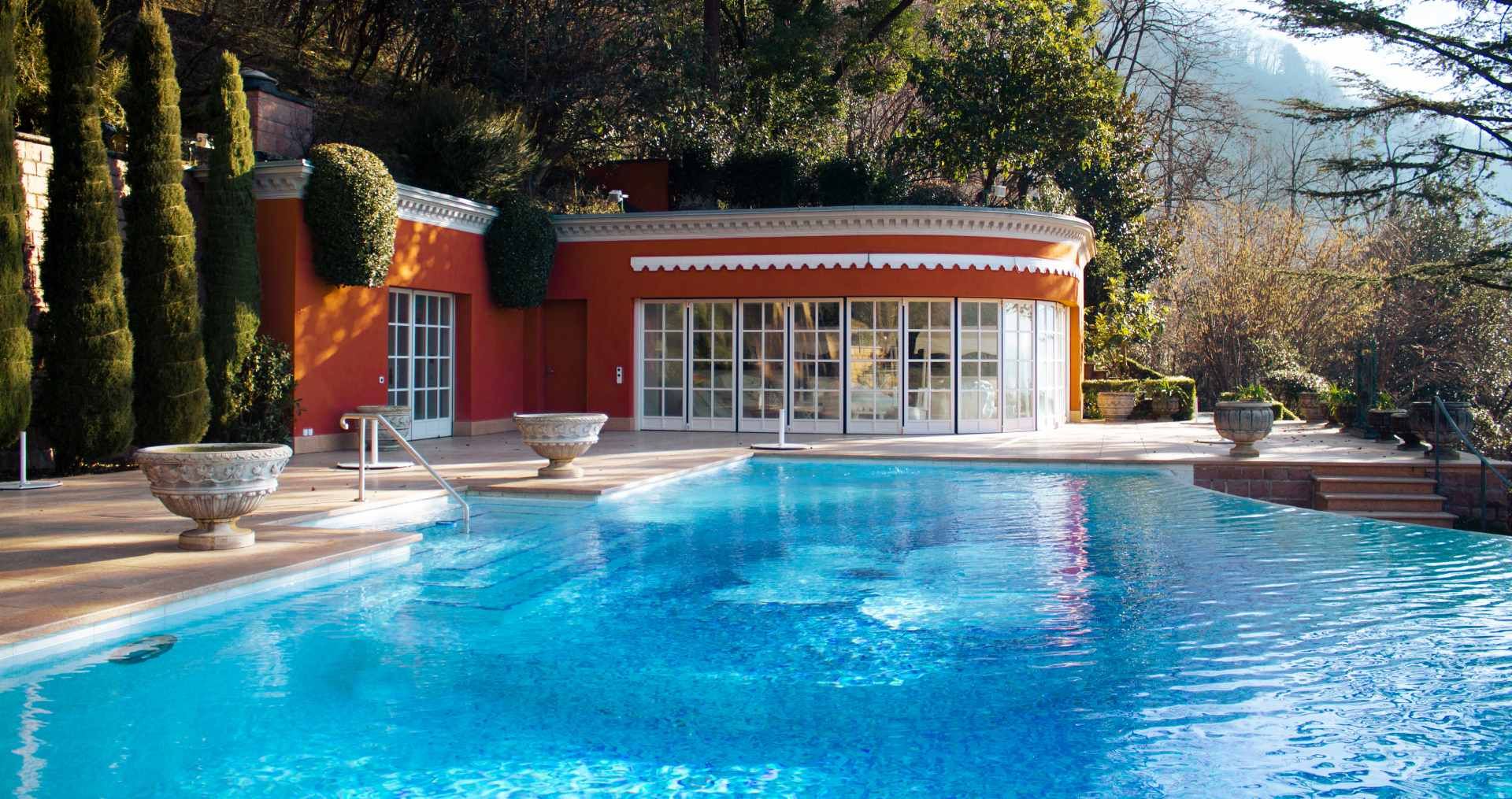 Una grande piscina con un edificio rosso sullo sfondo