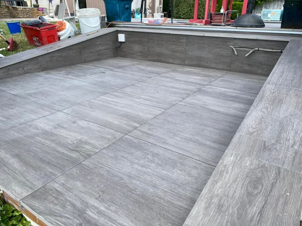 Terrasse carrelée de gris dans une cour arrière