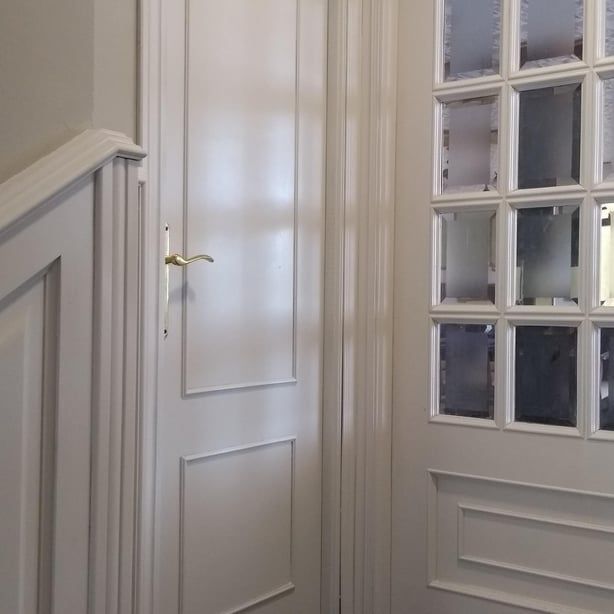 Una puerta blanca con una escalera al fondo.