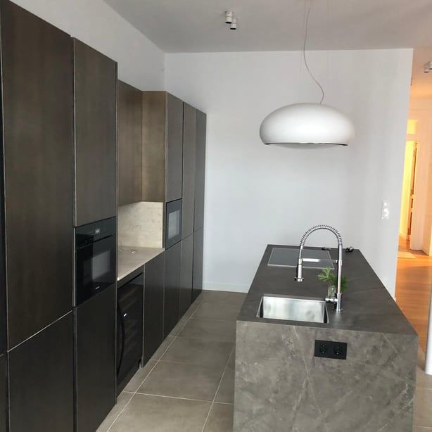 Una cocina con una gran isla y un fregadero.