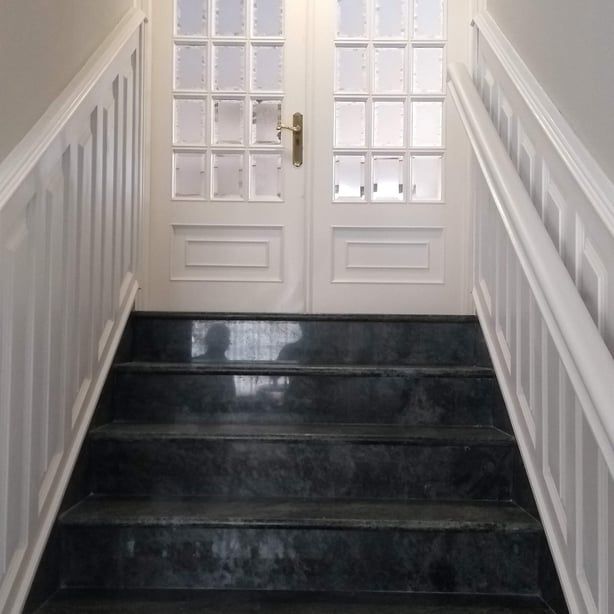 Un conjunto de escaleras que conducen a una puerta blanca.