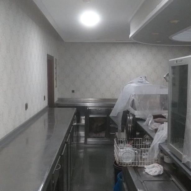 Una cocina con encimeras y gabinetes de acero inoxidable.