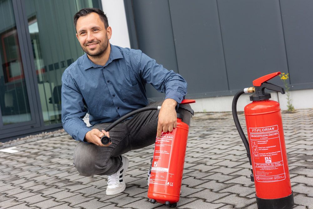 Ein Mann mit Schutzhelm und Sicherheitsweste hält ein Klemmbrett und schreibt darauf.