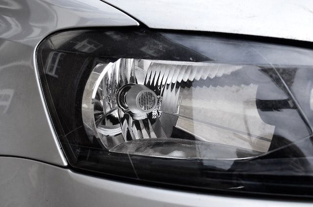 Un primer plano del faro de un coche plateado.