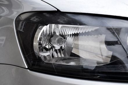 Un primer plano del faro de un coche plateado.