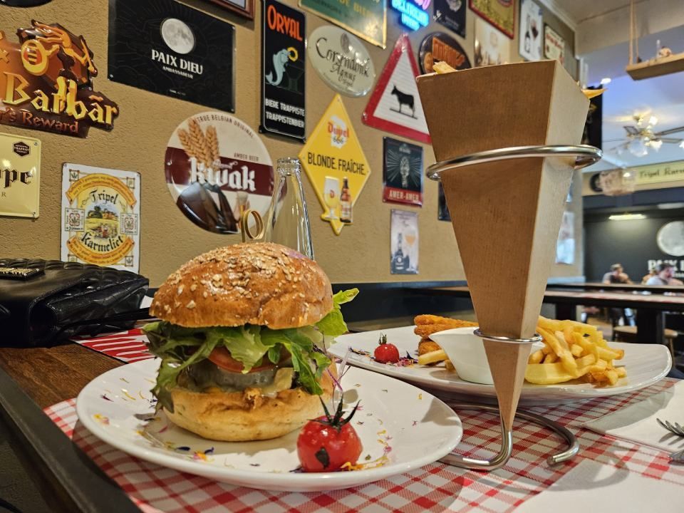 Un hamburger et des frites sont sur une assiette sur une table.