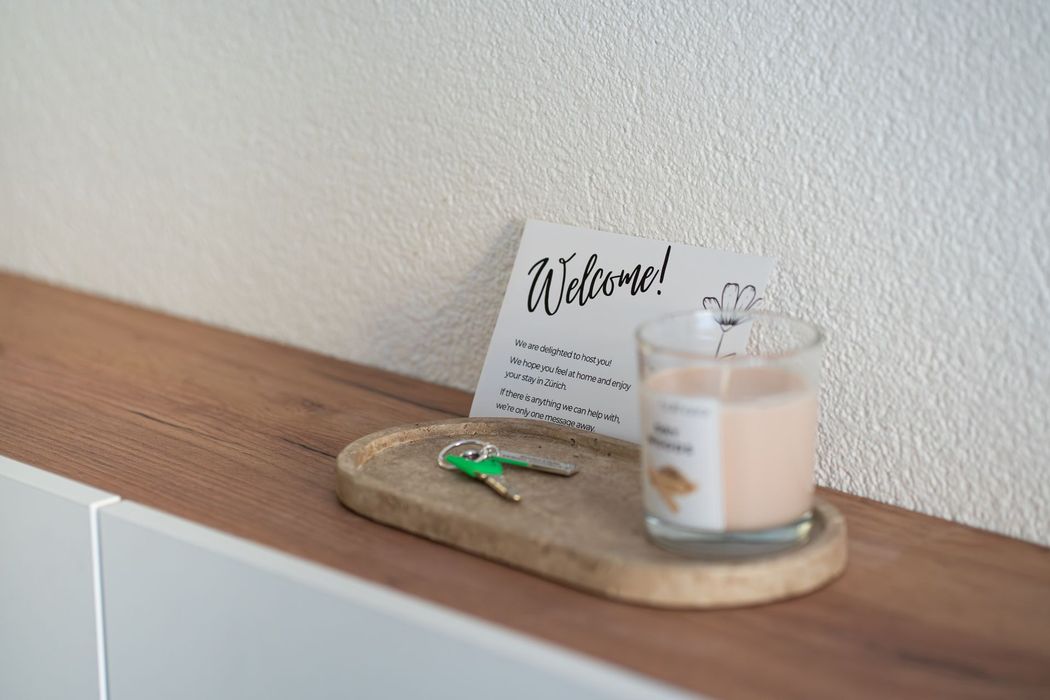Apartment keys in a small tray beside a welcome card at SwissVida.