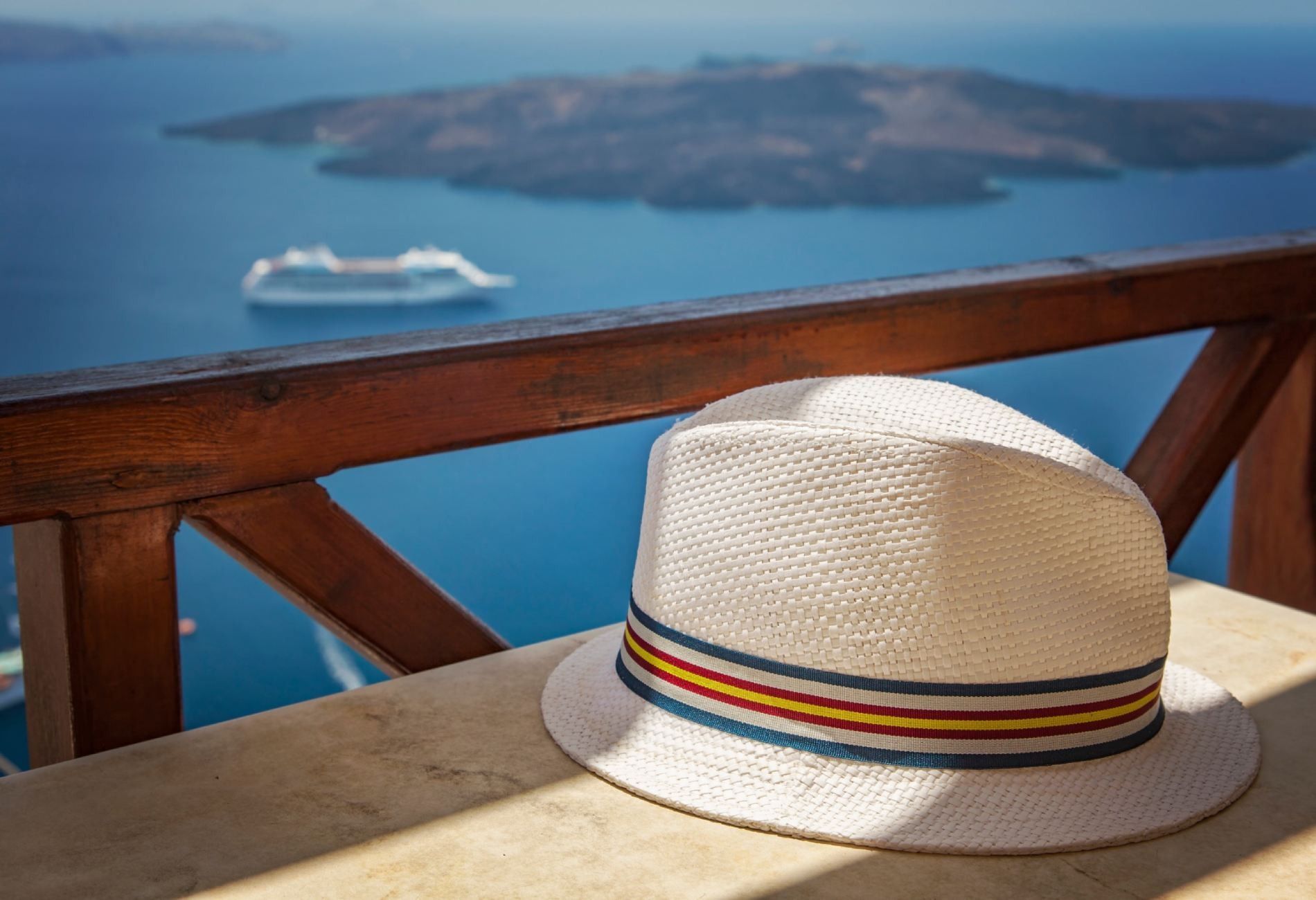 Un sombrero está sobre una mesa con vista al océano.