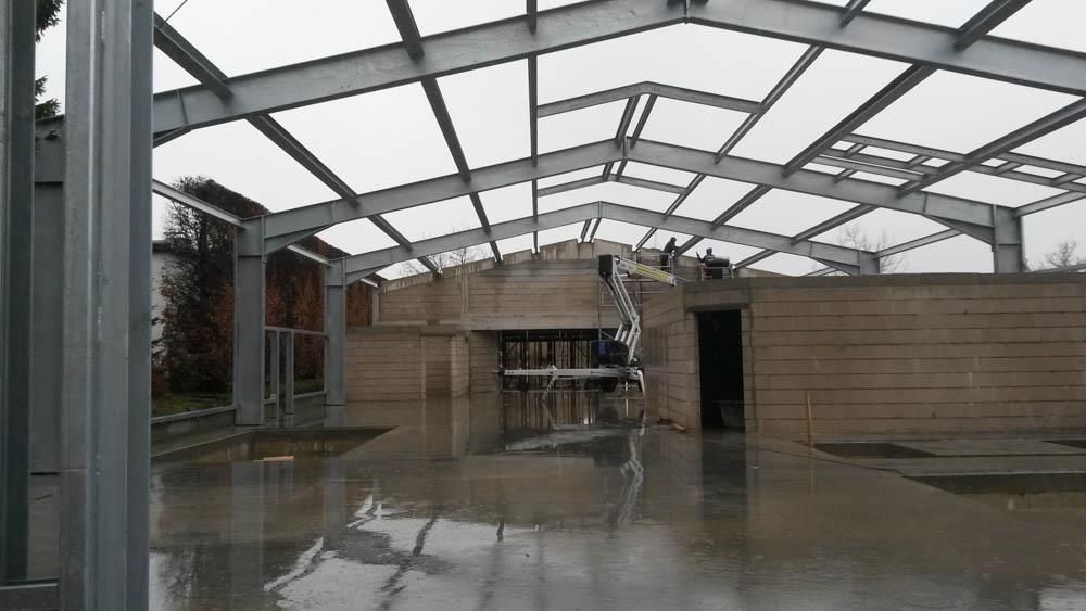 Im Regen wird eine große Metallkonstruktion errichtet