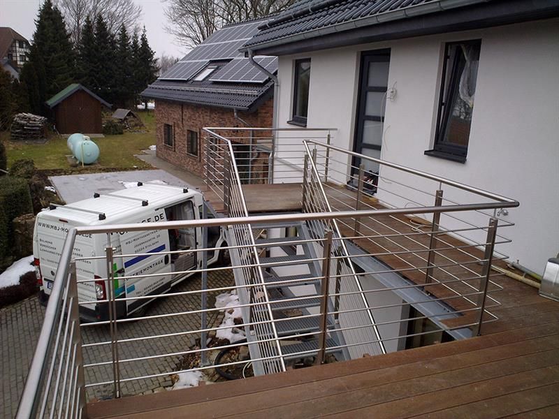 Ein weißer Lieferwagen steht vor einem Haus mit Sonnenkollektoren auf dem Dach
