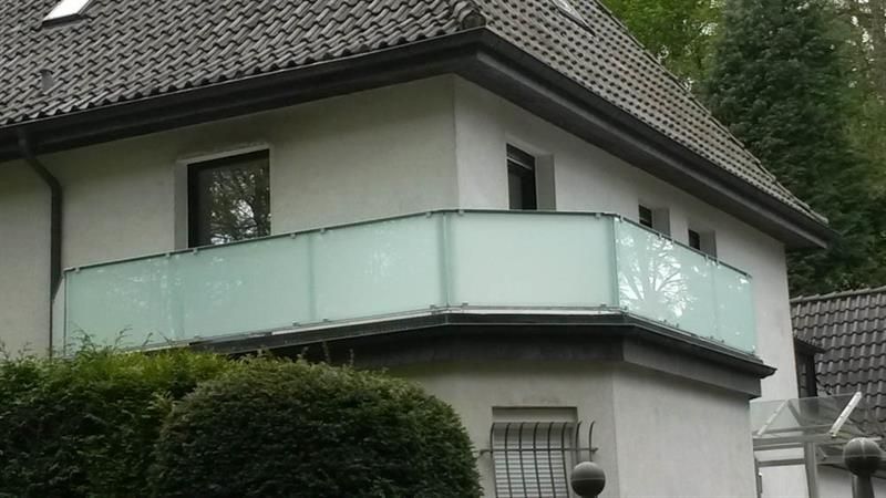 Ein weißes Haus mit einem Balkon an der Seite