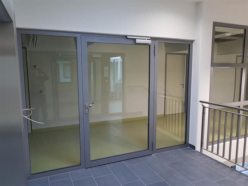 Ein Zimmer mit vielen Glastüren und einem Balkon