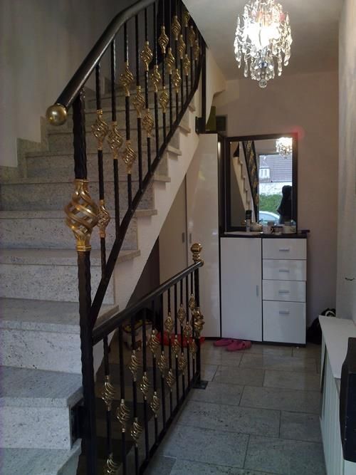 Ein Flur mit Treppe und einem Kronleuchter, der von der Decke hängt