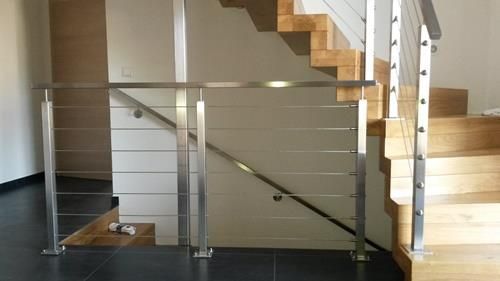 Eine Treppe mit Edelstahlgeländer und Holzstufen