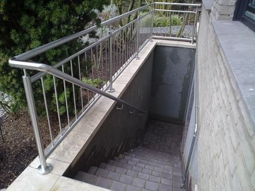 Eine Treppe mit Edelstahlgeländer, die in einen Keller führt.
