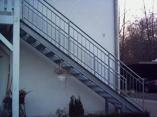 Eine Treppe mit einem Metallgeländer an der Seite eines Gebäudes