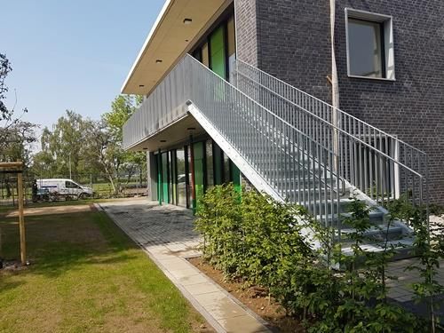 Ein Gebäude mit einer Treppe, die zu einem Balkon an der Seite hinaufführt.