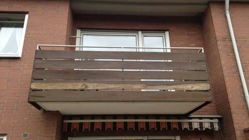 Ein Holzbalkon an der Seite eines Backsteingebäudes