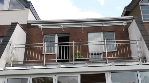 Ein Balkon mit einem Edelstahlgeländer auf einem Backsteingebäude
