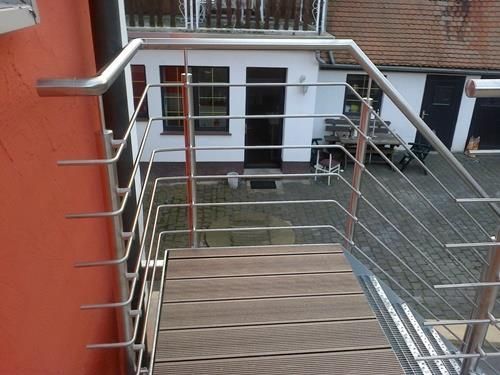 Eine Treppe mit Edelstahlgeländer und Holzstufen