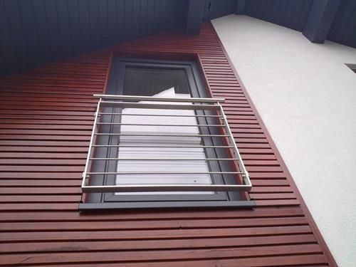 Ein Fenster mit einem Metallgeländer an der Seite eines Gebäudes