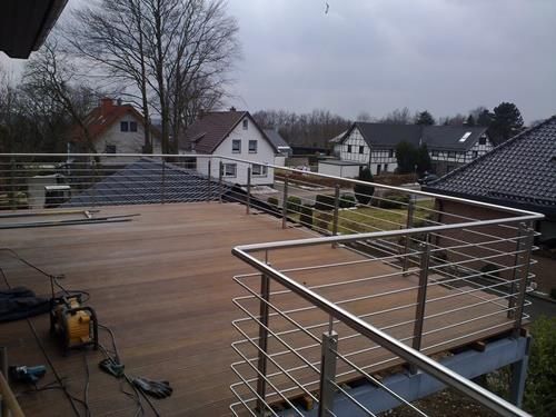 Ein Holzdeck mit Edelstahlgeländer und Treppe