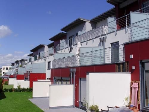 Eine Reihe rot-weißer Häuser mit Balkonen