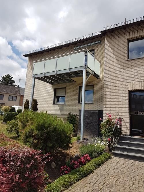 Ein Backsteinhaus mit einem Balkon an der Seite.