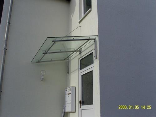 Ein weißes Gebäude mit einem Glasdach über einer Tür