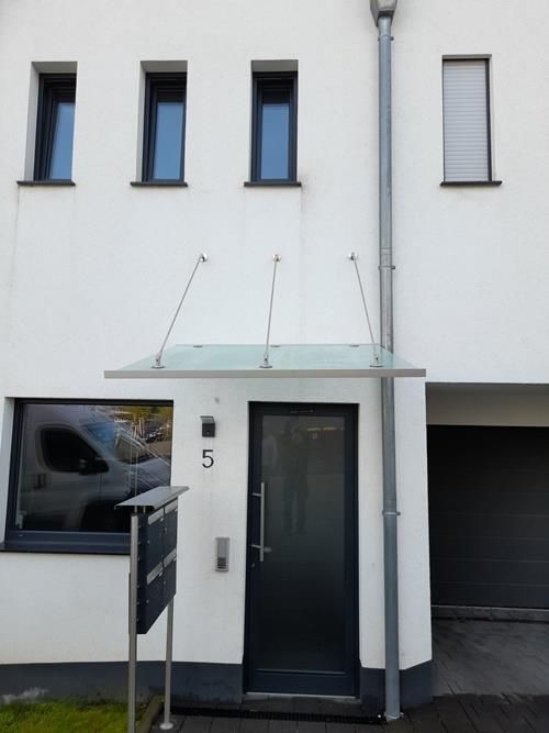 Ein weißes Haus mit einer schwarzen Tür und einem Briefkasten