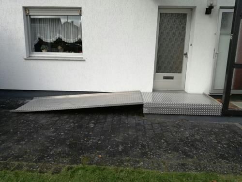Es gibt eine Rampe, die zur Eingangstür eines Hauses führt.