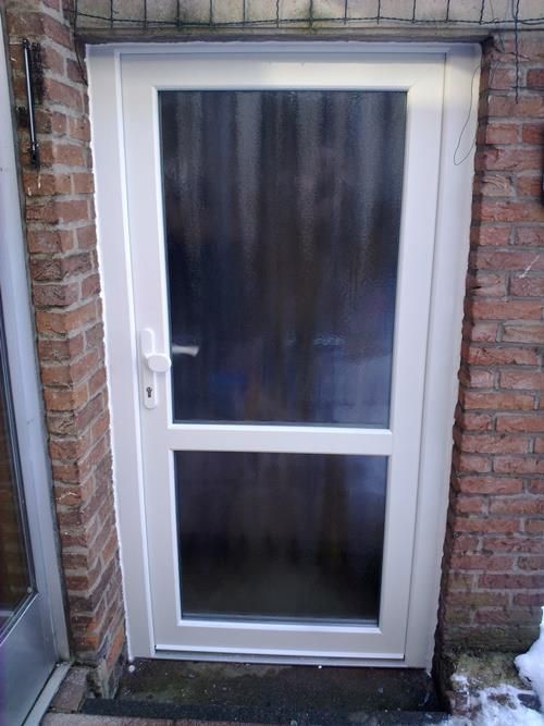 Eine weiße Tür mit einer Ziegelwand dahinter