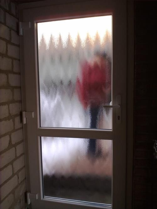 Eine Person in einer roten Jacke geht durch eine Tür