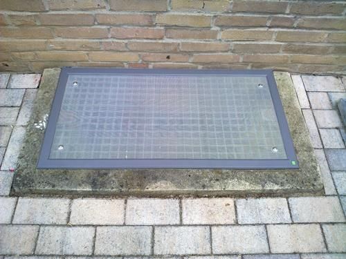 Eine Ziegelwand mit einer Fensterabdeckung darauf.